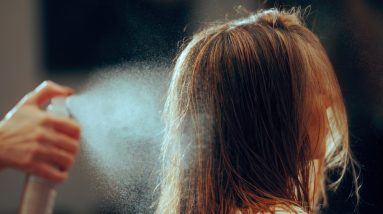 o imagine cu o sticlă de spray pentru volumul părului și o femeie cu părul plin de volum